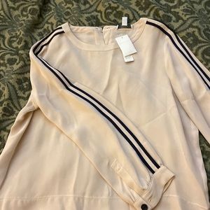 Blouse with piping along arm and covered button.